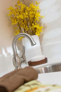 ein Waschbecken mit einem Wasserhahn und einer Vase gelber Blumen in der Unterkunft Mat-Su Resort in Wasilla