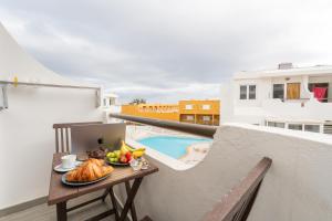 a table with a plate of food on a balcony at Brisa Marina by Maja FTV Ocean View in Antigua
