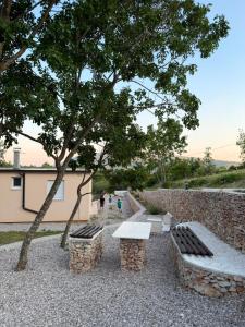 a park with two benches and a tree at Kuća za odmor Bela Goranci in Mostar
