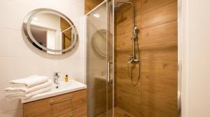 a bathroom with a shower with a sink and a mirror at Noce pod Gwiazdami in Sidzina