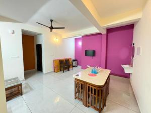 a living room with purple walls and a table at Havens Nature Homestay in Ambalavayal