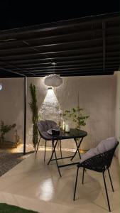 a table and chairs in a room with a wall at سكون in Al Baha