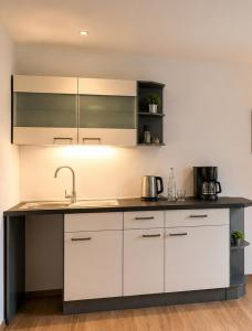 a kitchen with white cabinets and a sink at Gemütliche Ferienwohnung in Burgberg in Giengen an der Brenz