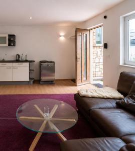 a living room with a couch and a glass table at Gemütliche Ferienwohnung in Burgberg in Giengen an der Brenz