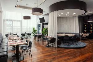 a restaurant with tables and chairs in a room at Courtyard by Marriott Prague Airport in Prague
