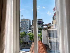 a window with a view of a city at A25 Hotel - 44 Hàng Bún in Hanoi