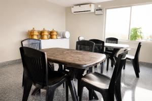 a dining room with a table and black chairs at Hotel Vilasa Grand in Guwahati