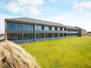 a large building with a grass field in front of it at Vedersø Holiday Center in Ulfborg