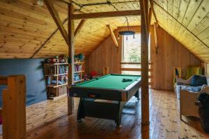 a room with a pool table in a house at Lisie Bagno - Domki w Lesie Mazury in Miłomłyn