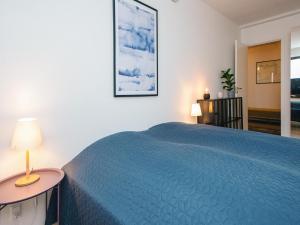 a bedroom with a bed with a blue bedspread at Vedersø Holiday Center in Ulfborg +127 photos