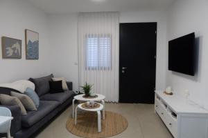 a living room with a couch and a table at צימר פסטורלי בהגושרים in HaGoshrim