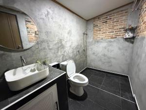 a bathroom with a sink and a toilet and a mirror at บ้านไม้ชายแดนกาแฟสดแอนด์โฮมสเตย์ in Ban Ba Nam Ron +14 photos