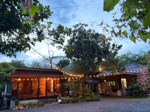 a house with string lights on it at บ้านไม้ชายแดนกาแฟสดแอนด์โฮมสเตย์ in Ban Ba Nam Ron