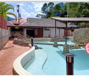 a swimming pool in a house with a building at บ้านไม้ชายแดนกาแฟสดแอนด์โฮมสเตย์ in Ban Ba Nam Ron