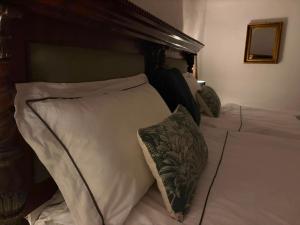 a bed with white pillows and a wooden headboard at Château la Gineste - Castle and Vineyard in Duravel