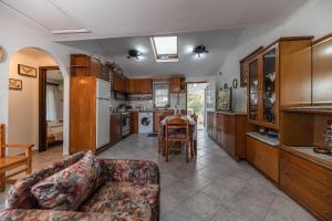 a living room with a couch and a kitchen at Villa Hara Kiotari in Gennadi +20 photos