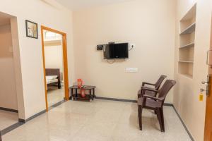 a room with a chair and a tv on the wall at KUKAL CASTLE in Tiruppūr