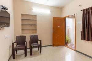 two chairs in a waiting room with a mirror at KUKAL CASTLE in Tiruppūr +9 photos