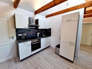 a kitchen with white cabinets and a white refrigerator at Ferienwohnung Brunnenaue in Sagard