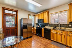 a kitchen with stainless steel appliances and wooden cabinets at Historic 2BR with Deck Games & Garage in Saint Louis