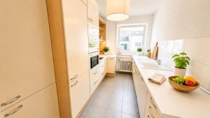 a kitchen with white cabinets and a bowl of fruit on the counter at Köln Pulheim Wellness Oase in Pulheim