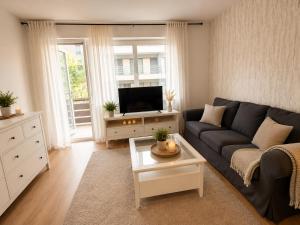 a living room with a couch and a tv at Köln Pulheim Wellness Oase in Pulheim