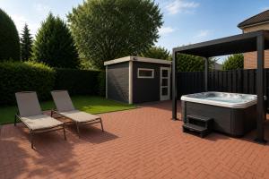 a patio with two chairs and a hot tub at Köln Pulheim Wellness Oase in Pulheim