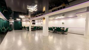 a large room with green chairs and tables in it at Noce pod Gwiazdami in Sidzina
