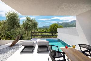 eine Terrasse mit Tisch und Stühlen und ein Swimmingpool in der Unterkunft Toska Tower in Chrisi Ammoudia