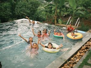 a group of children are in a swimming pool at HagiangHillside in Ha Giang