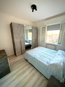 a bedroom with a bed and a dresser and a window at We4 apartment Maranello in Maranello