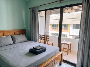 a bedroom with a bed and a large window at Orient Hotel in Jomtien Beach