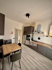 a kitchen with a wooden table and a dining room at We4 apartment Maranello in Maranello