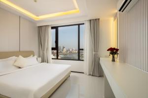 a bedroom with a white bed and a large window at Pinnacle Moments Residence in Phnom Penh +77 photos
