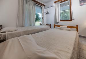 two beds in a room with a window at Villa Hara Kiotari in Gennadi