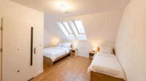 two beds in a room with two windows at Noce pod Gwiazdami in Sidzina
