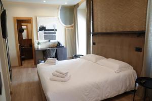 a bedroom with a white bed with towels on it at Notos Home in Bitonto