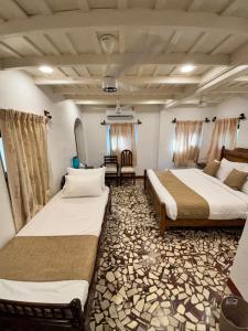 a room with two beds and a chair in it at Chettiparambil Heritage in Cochin