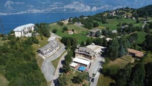 an aerial view of a house on a hill with a lake at Hotel Monte Baldo in Brenzone sul Garda