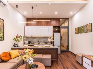 a living room with a couch and a kitchen at Gon De Home Ham Nghi in Ho Chi Minh City