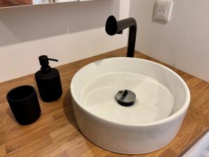 a white sink with a faucet and two soap bottles at La Halte Beaujolaise in Belleville-en-Beaujolais +5 photos