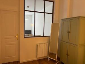 a room with a window and a ladder next to a cabinet at La Halte Beaujolaise in Belleville-en-Beaujolais