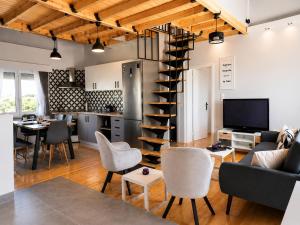 a living room and kitchen with a spiral staircase at Pegasus Pool Villas Kavala in Kavála