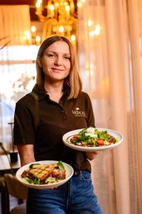 a woman is holding a plate of food at Dworek in Kolbuszowa