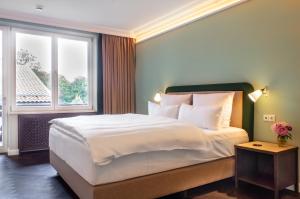 a bedroom with a large bed and a window at Bartl Apartments in Rottach-Egern