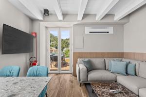 a living room with a couch and a tv at SeaFrontBonassola in Bonassola