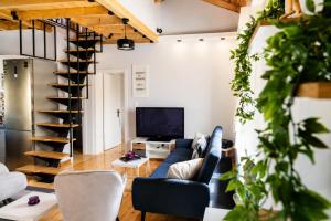 a living room with a blue couch and a staircase at Pegasus Pool Villas Kavala in Kavála +62 photos