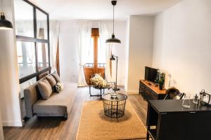a living room with a couch and a tv at Apartamentos Dacosta in Ribadeo