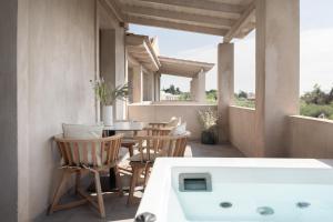 a bathroom with a tub and a table and chairs at Casa di Pierro in Lithakia