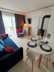 a living room with a table and a blue couch at VILLA KINGA ROWy in Rowy